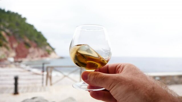 qualities of Herbs de Majorca liqueur on the terrace of a Port de Valldemossa restaurant with impressive view to the mountains and Mediterranean sea