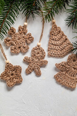 Set of crochet Christmas tree toys from natural jute. Knitted gingerbread man, Christmas tree, snowflake, flower. Handmade Cristmas decor. Copy space.