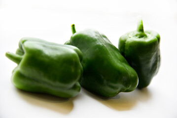 Juicy green and yellow pepper fruits on a white background. Beautiful shiny and delicious pepper.