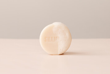 Round shape dry handmade shampoo bar with note 'shampoo' and foam, made of cold pressed oil, vegan formula,on pink background. Silicones, sulfates,artificial colorantes free, eco,no waste. Copy space.