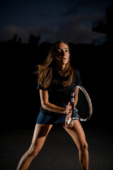 Close-up of athletic woman with racket in special pose which preparing to playing tennis