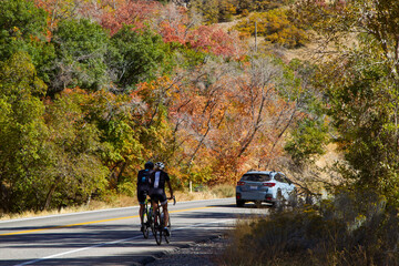 Obraz premium Man and woman ride their road bikes along the mountain road Big Cottonwood Canyon, Salt Lake City, Utah