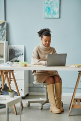 African young businesswoman working online on laptop while working at her workplace at office