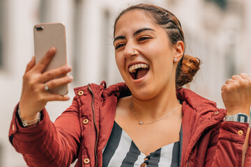 girl with braces and mobile phone with expression of joy or success