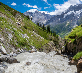 Fototapeta na wymiar The glacial stream with the Jungfrau, Mittaghorn and Grosshorn peaks in the Hineres Lauterbrunnental valley.