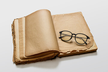 An old book with yellowed pages and glasses