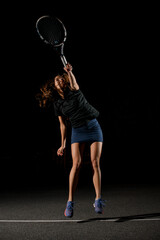 view on female tennis player with tennis racket in her hand bouncing to hit the tennis ball.