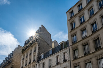 Obraz premium Paris, typical facades, beautiful buildings in Montmartre, sun’s rays 
