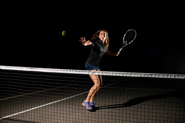 Fototapeta na wymiar great shot of tennis ball in air and female tennis player with racket ready to hit it