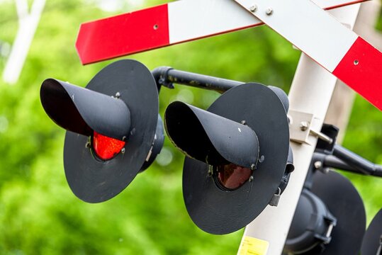Red and white railroad crossing sign with two warning lights