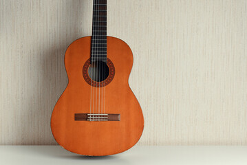 Fototapeta na wymiar Classical acoustic guitar on a light wall background. 