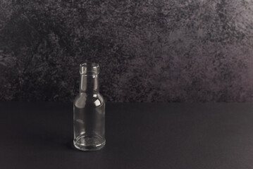 Little glass bottle on a dark background. Zero waste concept