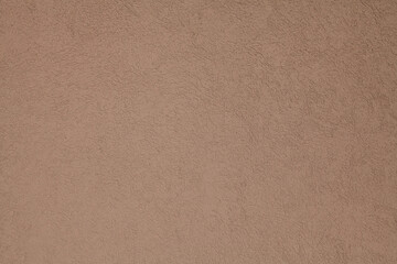Brown, terracotta texture and background. Decorated surface with round ornamental embossed pattern. Pale light-brown wall surface with abstract pattern.  Embossed ornament of building wall plastering