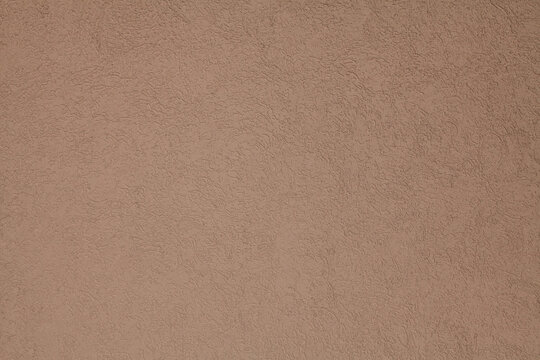 Brown, terracotta texture and background. Decorated surface with round ornamental embossed pattern. Pale light-brown wall surface with abstract pattern.  Embossed ornament of building wall plastering