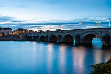 Maastricht, Netherlands 10-24-2022 Skyline of the Wyck area in downtown Maastricht with views on the iconic Servaas bridge and brewery. With a sunrise in Autumn coloring the sky in dramatic cloudscape