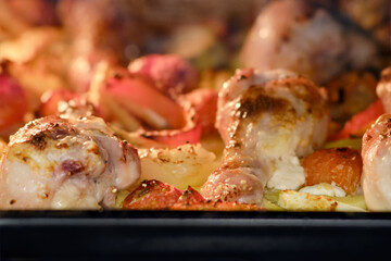 Cooking chicken with vegetables in the oven. Chicken legs and thighs with marinade, potatoes, tomatoes and paprika