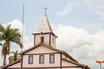 Torre da igreja com céu nublado ao fundo. O Santuário Nossa Senhora Aparecida fica na cidade de Aparecida de Goiânia.