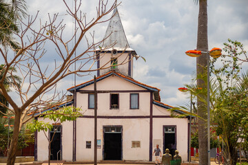 Igreja com uma árvore seca na frente, em um dia de céu nublado. O Santuário Nossa Senhora Aparecida fica na cidade de Aparecida de Goiânia.