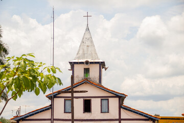 Torre da igreja com céu nublado ao fundo. O Santuário Nossa Senhora Aparecida fica na cidade de Aparecida de Goiânia.