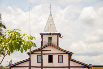 Torre da igreja com céu nublado ao fundo. O Santuário Nossa Senhora Aparecida fica na cidade de Aparecida de Goiânia.