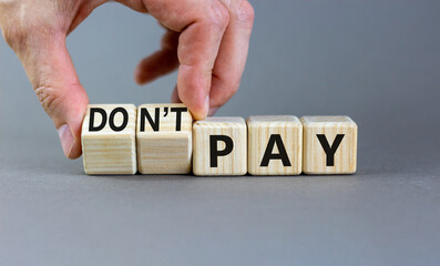 Do not pay symbol. Concept words do not pay on cubes. Businessman hand. Beautiful grey table grey background. Business, financial crisis and do not pay concept. Copy space.