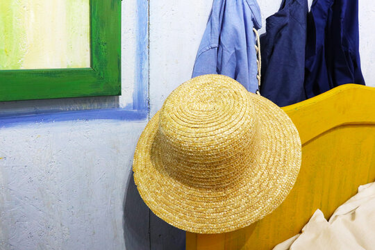 a straw hat is hanging on the bed