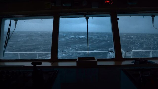 Storm at sea. Vessel's bridge. Windshield wiper works. Strong pitching. High waves rock ship.