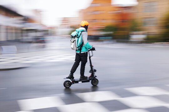 motion blur picture of an unrecognizable person with an electric scooter on a city street