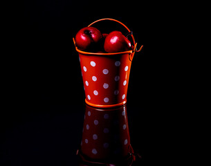 aluminum ice bucket laid in wait for use. stainless multi-colored bucket with red apples