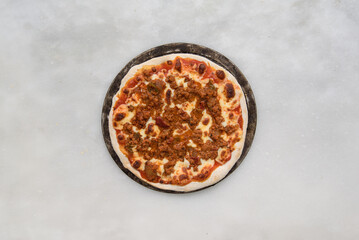 bolognese pizza over a white stone