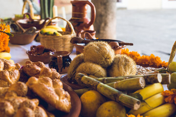 Traditional Mexican Day of the Dead altar with offerings of cempasuchil marigold flowers, food and pan de muerto in Mexico for the holiday and cultural celebration, honoring and tradition