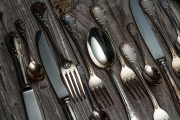 old spoons and cutlery on a wooden table - obrazy, fototapety, plakaty