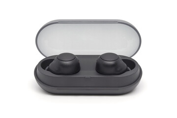 Wireless black bluetooth earphones with contactless charging isolated close-up on a white background