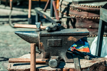 Blacksmith's hammer on a metal anvil in forge