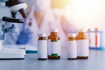 biochemical research scientist team working with microscope for coronavirus vaccine development in pharmaceutical research labolatory, selective focus