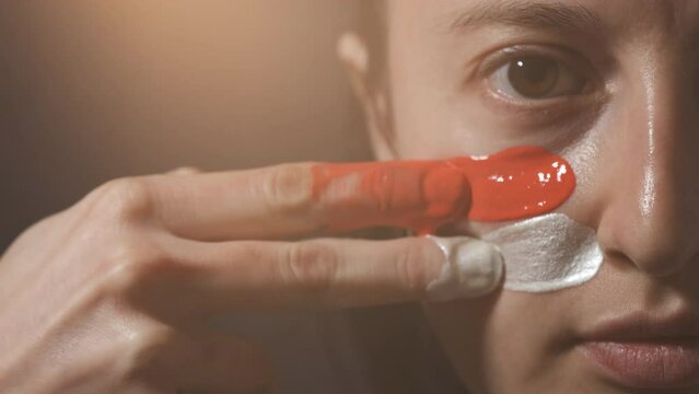 Supporter Painting Face and Looking at Camera. Football Fan Preparing for the Match. Colored Face with Flag Colors Red and White. Slow Motion 4K Prores 422