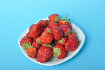 Strawberries on a plate on a blue background