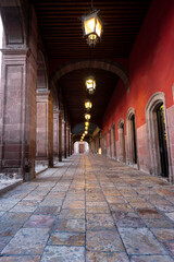 Rustic hallway with arches and lanterns n the historic center of the city of San Miguel De Allende, Mexico.The town is designated World Heritage Site by UNESCO