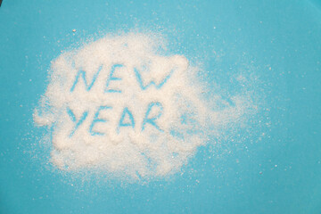 letters appear in the snow. The inscription New Year on a blue background