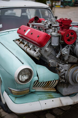 Vintage tuned car, with a large engine sticking out of its hood