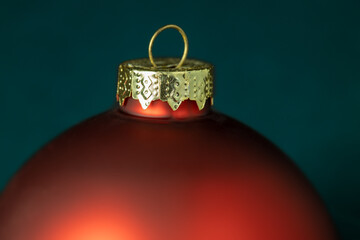 Closeup of a red christmas bauble on green background. Selective focus