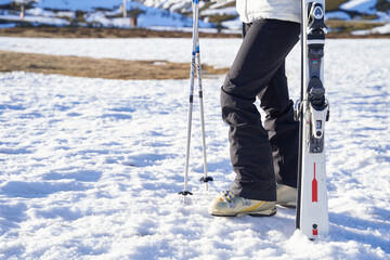 girl holding skis not person. only legs.