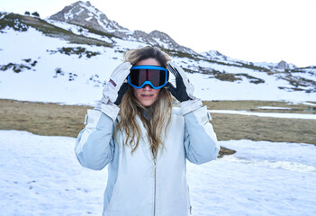 pretty girl puts on her snow goggles to protect herself.