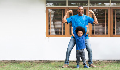 African American Father and Afro boy doing strong gesture
