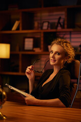 Purposeful young business woman, professional entrepreneur, reads a book. Business woman in a beautiful office in cinematic light. A beautiful portrait.