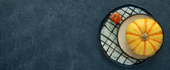 Plates with pumpkin and rowan on dark background with space for text