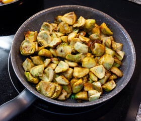 Appetizing artichokes fried in a pan. High quality photo