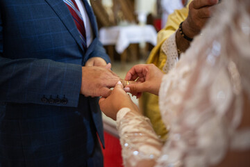 Panna Młoda zakłada pierścionek na palec. The bride puts the ring on her finger.