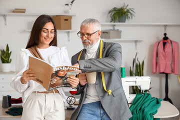 Mature fashion designer working with assistant in studio