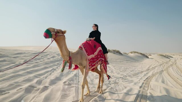 tourist woman riding camel at the desert
